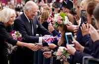 (FILES) In this file photo taken on September 13, 2022 Britain's King Charles III and Britain's Camilla, Queen Consort greet wellwishers as they arrive at Hillsborough Castle in Belfast, during his visit to Northern Ireland. - The coronation weekend for King Charles III, that will take place on May 6, 2023, will feature a star-studded concert, nationwide "big lunch" and volunteering initiative as well as the traditional ceremony and royal processions, Buckingham Palace announced late on January 21, 2022. (Photo by Niall Carson / POOL / AFP) (Photo by NIALL CARSON/POOL/AFP via Getty Images)