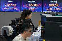 Currency traders watch monitors near the screens showing the Korea Composite Stock Price Index (KOSPI), top left, and the foreign exchange rate between U.S. dollar and South Korean won, top center, at the foreign exchange dealing room of the KEB Hana Bank headquarters in Seoul, South Korea, Friday, May 26.