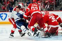 Detroit Red Wings defenseman Ben Chiarot (8) checks Toronto Maple Leafs left wing Michael Bunting (58) in the third period of an NHL hockey game Thursday, Jan. 12, 2023, in Detroit. (AP Photo/Paul Sancya)
