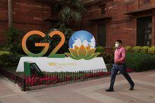 A man walks past a model of G20 logo outside the finance ministry in New Delhi, India, March 1, 2023. REUTERS/Anushree Fadnavis