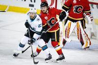 San Jose Sharks winger Barclay Goodrow, left, and Calgary Flames defenceman Rasmus Andersson fight for position. The Sharks beat the Flames 3-1 on Feb. 4, 2020.