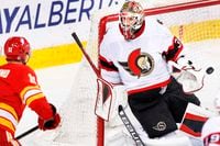 Ottawa Senators goalie Anton Forsberg, right, of Sweden, is scored on by Calgary Flames' Mikael Backlund, of Sweden, during second period NHL hockey action in Calgary, Alta., Sunday, May 9, 2021. THE CANADIAN PRESS/Larry MacDougal     