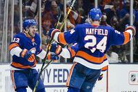 New York Islanders' Mathew Barzal (13) celebrates with teammate Scott Mayfield (24) after scoring a goal during the third period of Game 4 during an NHL hockey second-round playoff series against the Boston Bruins Saturday, June 5, 2021, in Uniondale, N.Y. The Islanders won 4-1. (AP Photo/Frank Franklin II)