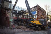 Debris falls to the ground as demolition resumes on the Winters Hotel after a body was found in the single room occupancy (SRO) building, in Vancouver, B.C., Friday, April 22, 2022. THE CANADIAN PRESS/Darryl Dyck