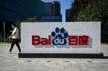 This file photo taken on September 6, 2022 shows an employee walking past the company logo at Baidu's headquarters in Beijing.