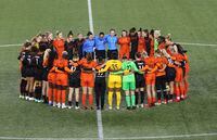 Portland Thorns and Houston Dash players, along with referees, gather at midfield, in demonstration of solidarity with two former NWSL players who came forward with allegations of sexual harassment and misconduct against a prominent coach, during the first half of an NWSL soccer match in Portland, Ore., Wednesday, Oct. 6, 2021. (AP Photo/Steve Dipaola)