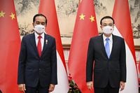 In this photo released by the Press and Media Bureau of the Indonesian Presidential Palace, Indonesian President Joko Widodo, left, pose for photographers with Chinese Premier Li Keqiang during their meeting in Beijing, China, Tuesday, July, 26, 2022. Widodo arrived in Beijing on Monday night on the first stop of a trip that will also take him to Japan and South Korea later this week. (Laily Rachev/Indonesian Presidential Palace via AP)