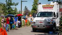 CORRECTS DATE TO WEDNESDAY, JUNE 30, 2021 IN JMC101-113 A Salvation Army EMS vehicle is setup as a cooling station as people line up to get into a splash park while trying to beat the heat in Calgary, Alta., Wednesday, June 30, 2021. Environment Canada warns the torrid heat wave that has settled over much of Western Canada won't lift for days. THE CANADIAN PRESS/Jeff McIntosh