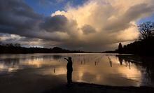 Aldo Cabrera, of Forestville, Calif., photographs the sunset at Wholer Road in Forestville, Calif., as the Russian River and Mark West Creek floods vineyards, Thursday, Feb. 14, 2019. Waves of heavy rain pounded California on Thursday, trapping people in floodwaters, washing away a mountain highway, triggering a mudslide that destroyed homes and forcing residents to flee communities scorched by wildfires last year. (Kent Porter/The Press Democrat via AP)