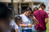 UVALDE, TEXAS - MAY 24: The Rodriguez family comforts each other while paying their respects at a memorial dedicated to the 19 children and two adults murdered on May 24, 2022 during the mass shooting at Robb Elementary School on May 24, 2023 in Uvalde, Texas. Today marks the 1-year anniversary of the mass shooting at the school. 19 children and two teachers were killed when a gunman entered the school, opening fire on students and faculty. (Photo by Brandon Bell/Getty Images)