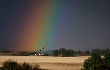 A pumpjack draws out oil and gas from a well head as a rainbow shines down on it near Calgary, Alta., Sunday, May 28, 2023. THE CANADIAN PRESS/Jeff McIntosh