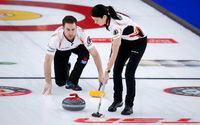 Team Einarson/Gushue third Brad Gushue, left, makes a shot as skip Kerri Einarson sweeps while they play Team Sahaidak/Lott during the Canadian Mixed Doubles Curling Championship final in Calgary, Alta., Thursday, March 25, 2021.THE CANADIAN PRESS/Jeff McIntosh