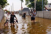 teenagers try to get through the flooded street of Mykolaiv Yacht Club area. Mykolaiv, Ukraine.
