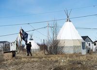 A women takes down laundry on the Attawapiskat First Nation, Ont., on Tuesday, April 19, 2016. Many First Nations, northern and Indigenous communities are struggling to cope with dual states of emergency, thanks to the pandemic and its impacts on those suffering from mental illness and addictions.That's according to a new report from a committee of MPs who spent the last year studying the effects of COVID-19 on Canada's Indigenous populations. THE CANADIAN PRESS/Nathan Denette