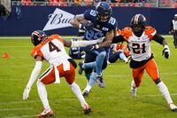Toronto Argonauts running back D.J. Foster (29) avoids a tackle by BC Lions defensive back Garry Peters (4) and Jordan Williams (21) during first half CFL action in Toronto on Saturday, Oct. 30, 2021. THE CANADIAN PRESS/Evan Buhler