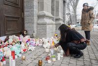 A woman lights a candle at a memorial outside a church close to the site of a daycare centre in Laval, Que, Thursday, February 9, 2023, where a bus crashed into the building killing two children. The parents of one of the two children who died have paid tribute to their four-year-old daughter in a letter sent to Quebec media.THE CANADIAN PRESS/Graham Hughes