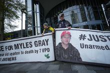 Protesters hold banners with a photograph of Myles Gray, who died following a confrontation with several police officers in 2015, before the start of a coroner's inquest into his death, in Burnaby, B.C., on Monday, April 17, 2023. The five jury members at the British Columbia coroner's inquest have begun their deliberations after hearing 11 days of testimony about a beating by Vancouver police officers and the death of Myles Gray.THE CANADIAN PRESS/Darryl Dyck