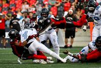 Toronto Argonauts quarterback McLeod Bethel-Thompson (4) gets tackled by Ottawa Redblacks defensive back Patrick Levels (3) as Redblacks linebacker Frankie Griffin (28) dives through the air towards them, during second half CFL football action in Ottawa on Saturday, Sept. 10, 2022. THE CANADIAN PRESS/Justin Tang