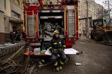 A firefighter rests as emergency workers clear rubble and look for victims at the site of the Russian attack on an apartment building in Dnipro, Ukraine on Jan. 16, 2023. At least 40 people were killed in the missile attack, with dozens still missing. (Lynsey Addario/The New York Times) — NO SALES —