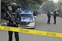 Police officers secure a road leading to a police station where a bomb exploded in Bandung, West Java, Indonesia, Wednesday, Dec. 7, 2022. A man blew himself up Wednesday at a police station on Indonesia's main island of Java in what appeared to be the latest in a string of suicide attacks in the world's most populous Muslim nation. (AP Photo/Kholid Parmawinata)