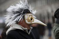 A masked man walk in St. Mark's Square in Venice, Italy, Sunday, Jan. 24, 2016. The Venice carnival in the historical lagoon city attracts people from around the world.  (AP Photo/Luca Bruno)                                                                                                                                                                                                                                                      