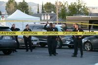 Los Angeles police investigate the scene of a fatal shooting in a shopping center parking lot in the San Fernando Valley area of Los Angeles on Saturday, April 1, 2023. (AP Photo/Damian Dovarganes)