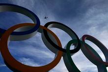 FILE - A passenger jet flies over the Olympic rings on display outside the Olympic Stadium where the athletic events are underway at the 2020 Summer Olympics Thursday, Aug. 5, 2021, in Tokyo, Japan. Mexico has declared its desire to host the Summer Olympics in 2036 or 2040 and says it already has most of the sports infrastructure required. Interest in hosting the 2036 Olympics had earlier been expressed by officials in countries including Egypt, England, India, Indonesia, Qatar and South Korea. Mexico City hosted the Summer Games in 1968.  (AP Photo/Charlie Riedel, File)