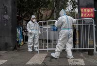 BEIJING, CHINA - NOVEMBER 24: Epidemic control workers wear protective suits as they move a barrier fence in an area under lockdown to prevent the spread of COVID-19 on November 24, 2022 in Beijing, China. China recorded its highest number of COVID-19 cases since the pandemic began Wednesday, as authorities stuck to their strict zero tolerance approach to containing the virus with lockdowns, mandatory testing, mask mandates, and quarantines as it struggles to contain outbreaks. In an effort to try to bring rising cases under control, the government last week closed most stores and restaurants for inside dining, switched schools to online studies, and asked people to work from home. (Photo by Kevin Frayer/Getty Images)