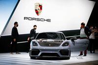 Attendees look at the 2022 Porsche 718 Cayman GT4 RS during the 2021 LA Auto Show in Los Angeles on Nov. 17, 2021.