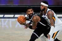 FILE - Utah Jazz's Royce O'Neale, right, defends Brooklyn Nets' Kyrie Irving (11) during the first half of an NBA basketball game  in New York, in this Tuesday, Jan. 5, 2021, file photo. Kyrie Irving rejoined the Brooklyn Nets on Tuesday, Jan. 19, 2021, saying he took a leave of absence because he just needed a pause. Irving practiced with the team and could play Wednesday in Cleveland. (AP Photo/Frank Franklin II, File)
