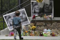 FILE - A boy looks at a memorial for Tylee Ryan and Joshua "JJ" Vallow in Rexburg, Idaho, on June 11, 2020. The sister of Tammy Daybell, who was killed in what prosecutors say was a doomsday-focused plot, told jurors Friday, April 28, 2023, that her sister's funeral was held so quickly that some family members couldn't attend. The testimony came in the triple murder trial of Lori Vallow Daybell, who is accused along with Chad Daybell in Tammy's death and the deaths of Vallow Daybell's two youngest children. (John Roark/The Idaho Post-Register via AP, File)