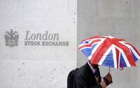 A worker shelters from the rain under a Union Flag umbrella as he passes the London Stock Exchange in London on Oct. 1, 2008.