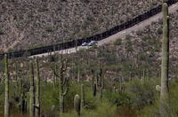 FILE - U.S. Customs and Patrol Patrol agents sit along a section of the international border wall that runs through Organ Pipe Cactus National Monument, Thursday, Aug. 22, 2019 in Lukeville, Ariz. The Border Patrol says one of its agents rescued an infant and a toddler Thursday, Aug. 25, 2022, who were left alone by migrant smugglers in the park. (AP Photo/Matt York, File)
