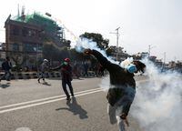 A demonstrator hurls back a tear gas towards the police during a protest against the $500 million U.S. infrastructure grant under the Millennium Challenge Corporation (MCC) near the parliament in Kathmandu, Nepal February 24, 2022. REUTERS/Navesh Chitrakar
