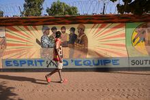 A man walks past a mural in Ouagadougou, Burkina Faso, Wednesday March 1, 2023. Burkina Faso has been wracked by violence linked to al-Qaida and the Islamic State group that has killed thousands, but some civilians say they are even more afraid of Burkina Faso’s security forces, whom they accuse of extrajudicial killings. The military junta has denied its security forces were involved, but a frame-by-frame analysis by The Associated Press of the 83-second video shows the killings happened inside a military base in the country’s north.  (AP Photo)