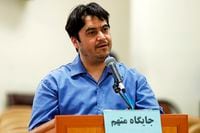 In this June 2, 2020 photo, journalist Ruhollah Zam speaks during his trial at the Revolutionary Court, in Tehran, Iran. Iran. The judiciary spokesman, Gholamhossein Esmaili, announced Tuesday, June 30, 2020 that Zam, a journalist whose online work helped inspire the 2017 economic protests and who returned from exile to Tehran was sentenced to death. The Persian writing on the podium reads, "defendant's place." (Ali Shirband/Mizan News Agency via AP)