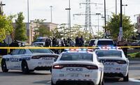 Police vehicles and officers are seen behind tape at a scene in Mississauga, Ont., Monday, Sept. 12, 2022. A Toronto police officer has been fatally shot and a suspect is in custody after two separate shootings left two dead and three injured in the Greater Toronto Area on Monday afternoon. THE CANADIAN PRESS/Arlyn McAdorey