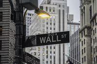 A street light brightens a Wall Street sign outside the New York Stock Exchange, Oct. 3, 2022, in New York