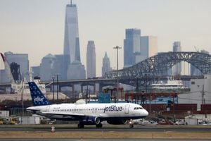 FILE PHOTO: A JetBlue passenger jet lands with New York City as a backdrop, at Newark Liberty International Airport, New Jersey, U.S. December 6, 2019. REUTERS/Chris Helgren/File Photo