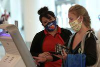A Southwest Airlines Co. employee wears a protective mask while assisting a passenger at Los Angeles International Airport (LAX) on an unusually empty Memorial Day weekend during the COVID-19 pandemic in Los Angeles on May 23, 2020.