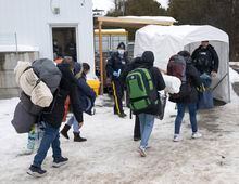 A family of asylum seekers from Columbia is met by RCMP officers after  crossing the border at Roxham Road into Canada Thursday, February 9, 2023  in Champlain, New York. THE CANADIAN PRESS/Ryan Remiorz