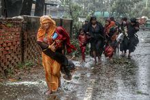 Residents of Teknaf, Bangladesh, evacuate from their homes seeking shelter as Cyclone Mocha tears through the region on May 14, 2023. 