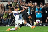 Vancouver Whitecaps defender Ranko Veselinovic, left, defends against Los Angeles FC forward Denis Bouanga (99) during the second half of an MLS soccer match in Los Angeles, Saturday, June 24, 2023. (AP Photo/Ashley Landis)
