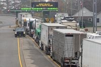 Vehicles sit idling on Thousand Island Parkway waiting to cross into the US, on Monday Nov. 8, 2021. The Canada Border Services Agency said Wednesday that a vaccine mandate for truckers would not come into effect this Saturday as planned. THE CANADIAN PRESS/Lars Hagberg