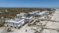 Water streams past buildings on the oceanfront after Hurricane Ian passed by the area, Friday, Sept. 30, 2022, in Sanibel Island, Fla. (AP Photo/Steve Helber)