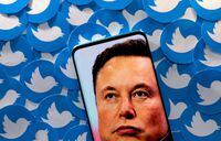 FILE PHOTO: An image of Elon Musk is seen on a smartphone placed on printed Twitter logos in this picture illustration taken April 28, 2022. REUTERS/Dado Ruvic/Illustration/File Photo
