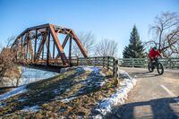 A cyclist exits a converted train bridge which connects downtown Fredericton, NB, with the north side of the city. The popular recreational bridge stretches across the St. John (Wolastoq) River and connects to a large network of trails that extend beyond the city and into the surrounding forests. (01/12/2024)(Chris Donovan/The Globe and Mail)