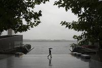 A pedestrian walks with an umbrella along the empty waterfront as heavy rain falls in Halifax on Thursday, September 14, 2023. Residents in Nova Scotia and New Brunswick are being told to prepare for strong winds and more heavy rain this weekend as Hurricane Lee is expected to make landfall as a post-tropical storm.Darren Calabrese/The Globe and Mail