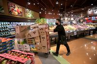 Victor Quintero, a produce clerk replenishes shelves at the Laird Sobeys at Leaside, on Nov. 26 2020.
