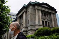 FILE PHOTO: A man wearing a protective mask stands in front of the headquarters of the Bank of Japan amid the coronavirus disease (COVID-19) outbreak in Tokyo, Japan, May 22, 2020.REUTERS/Kim Kyung-Hoon